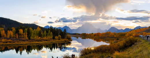 Golden aspens and distant mountains reflected in still water at Oxbow Bend